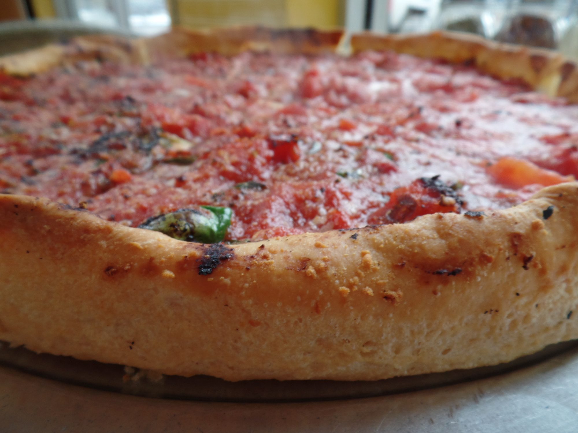 Close-up of a tall, golden deep dish crust